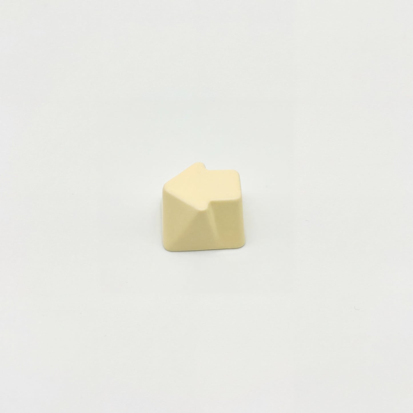Sculpted arrow custom keycap cream white die-cast metal smooth lacquer top view on white background