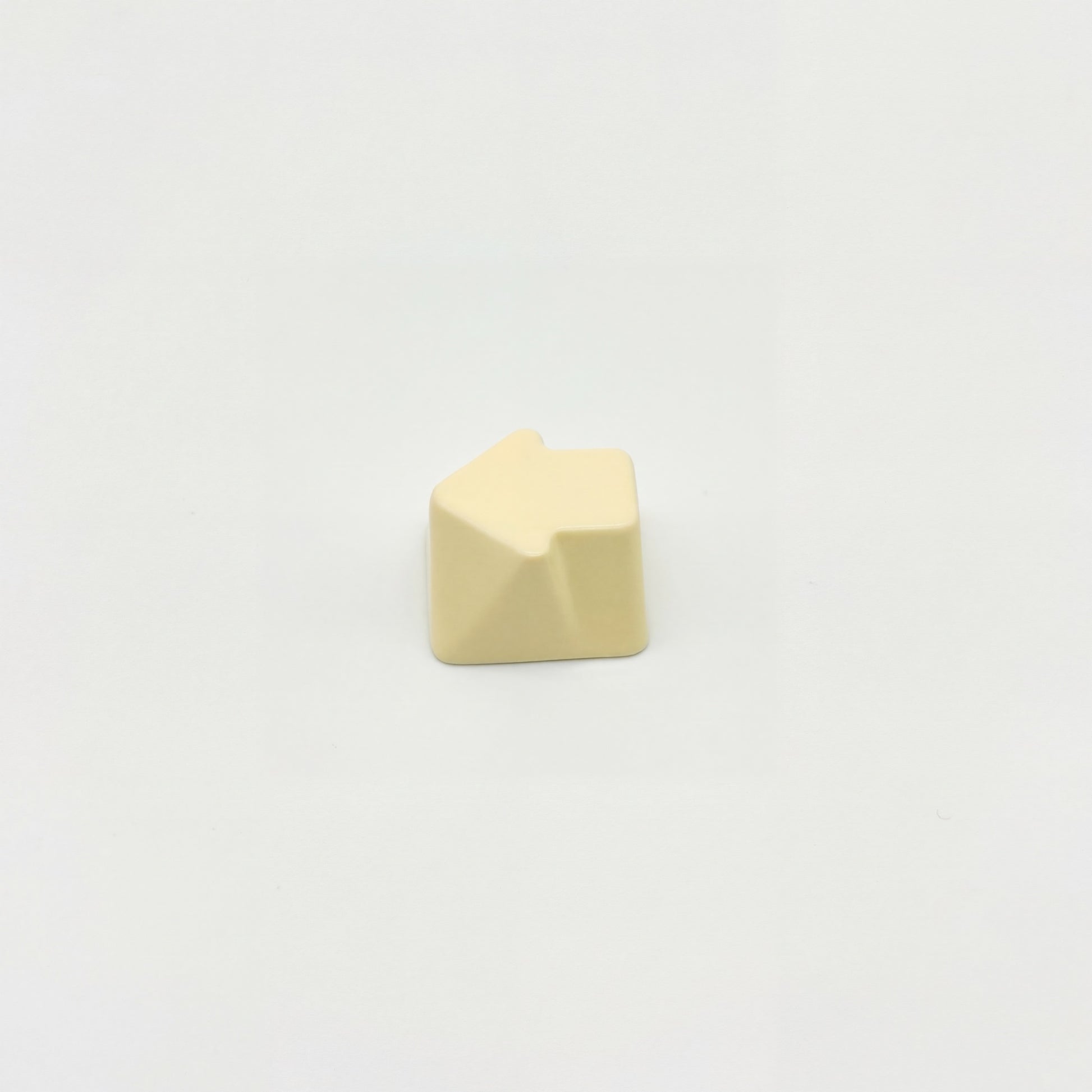 Sculpted arrow custom keycap cream white die-cast metal smooth lacquer top view on white background
