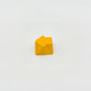Sculpted arrow custom keycap golden yellow die-cast metal smooth lacquer top view on white background