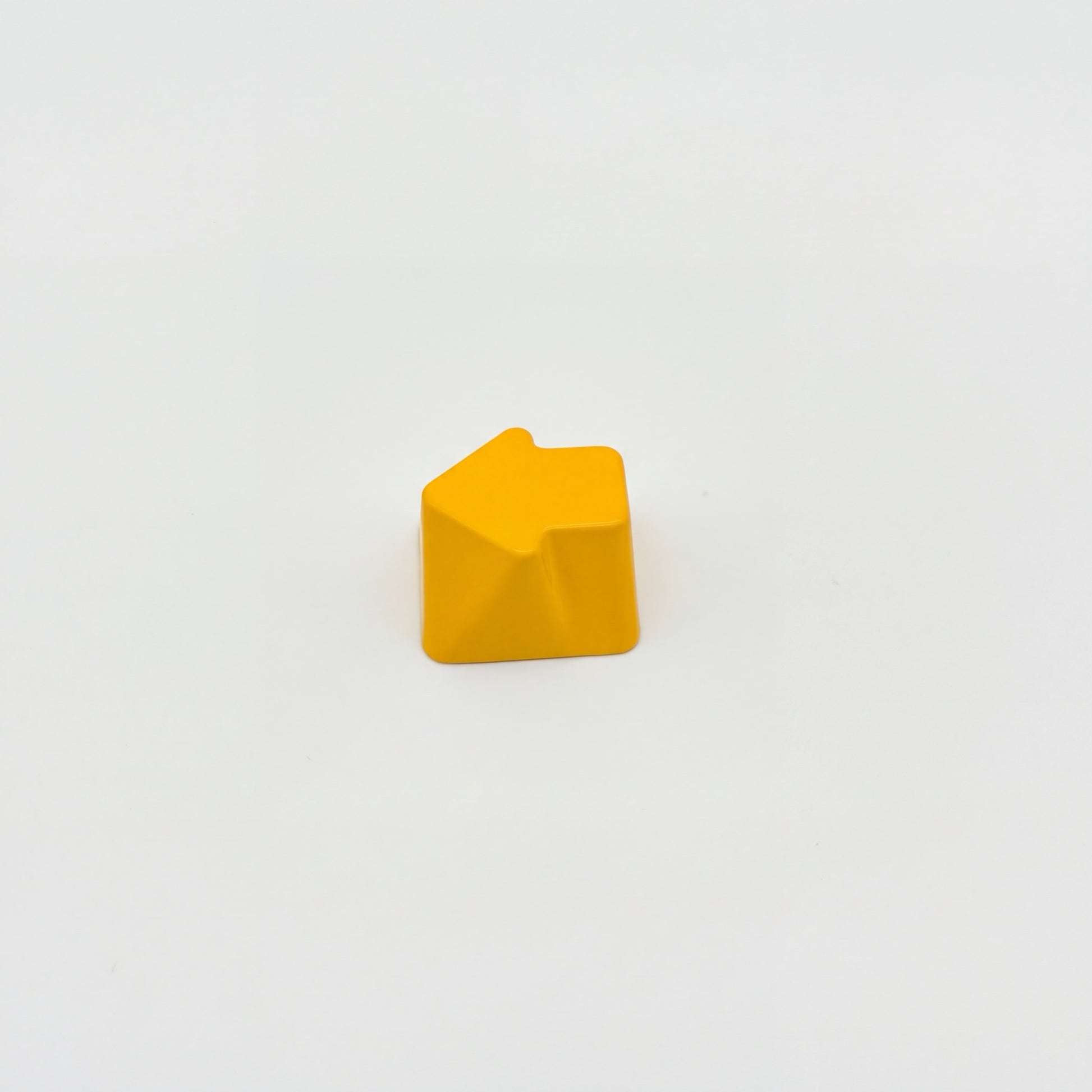 Sculpted arrow custom keycap golden yellow die-cast metal smooth lacquer top view on white background