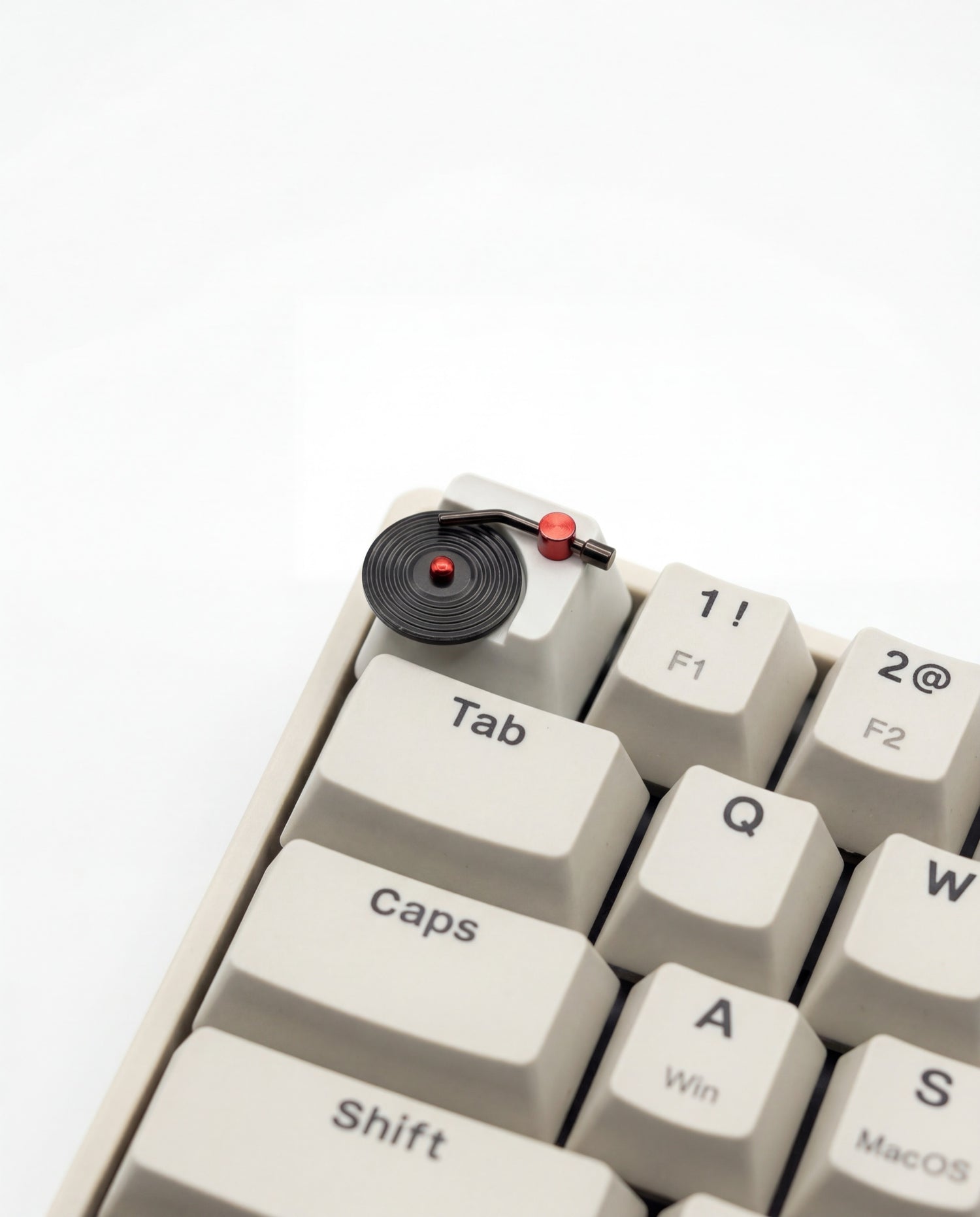 Vinyl record artisan keycap with spinning magnetic disc and stainless steel tonearm, macro product shot on white background, Cherry MX compatible