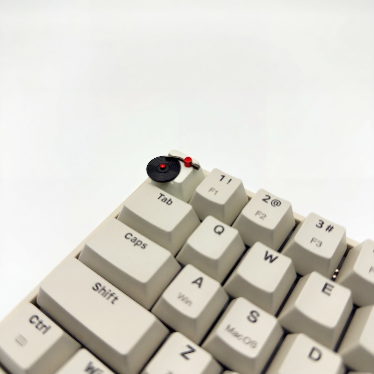 Spinning vinyl record artisan keycap on ESC key of mechanical keyboard close up side view