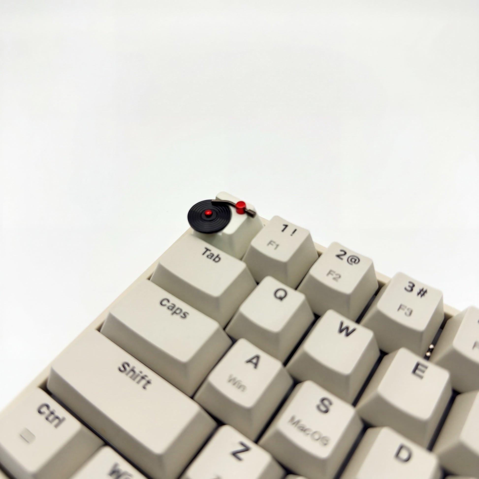Spinning vinyl record artisan keycap on ESC key of mechanical keyboard close up side view